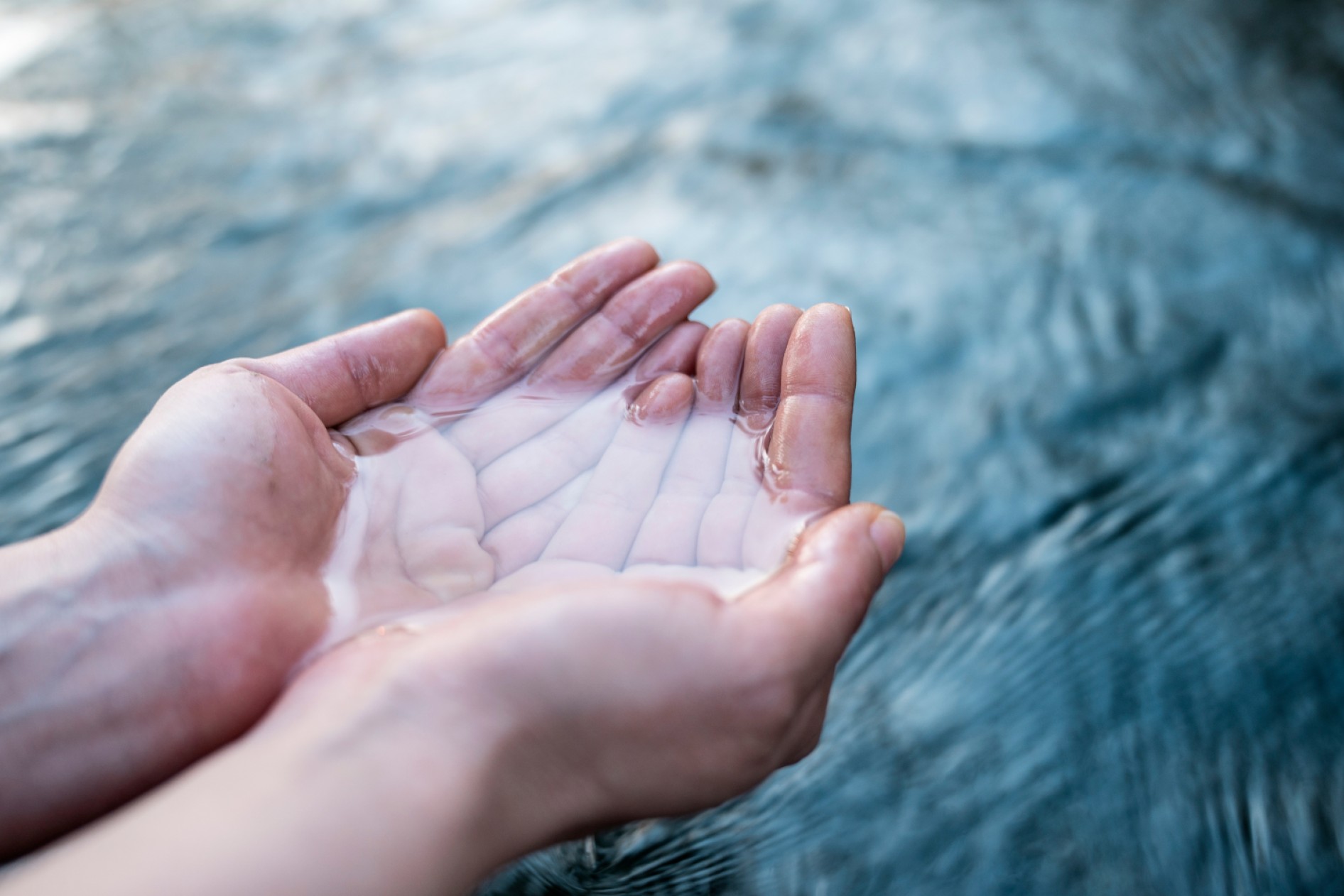 A female hand touching the river water